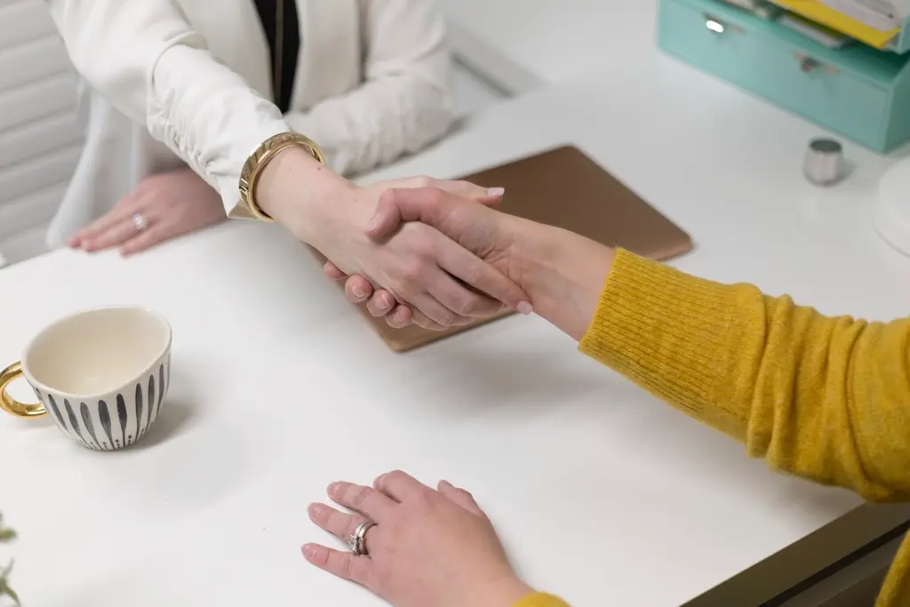 Aperto de mãos em reunião de negócios sobre mesa de escritório
